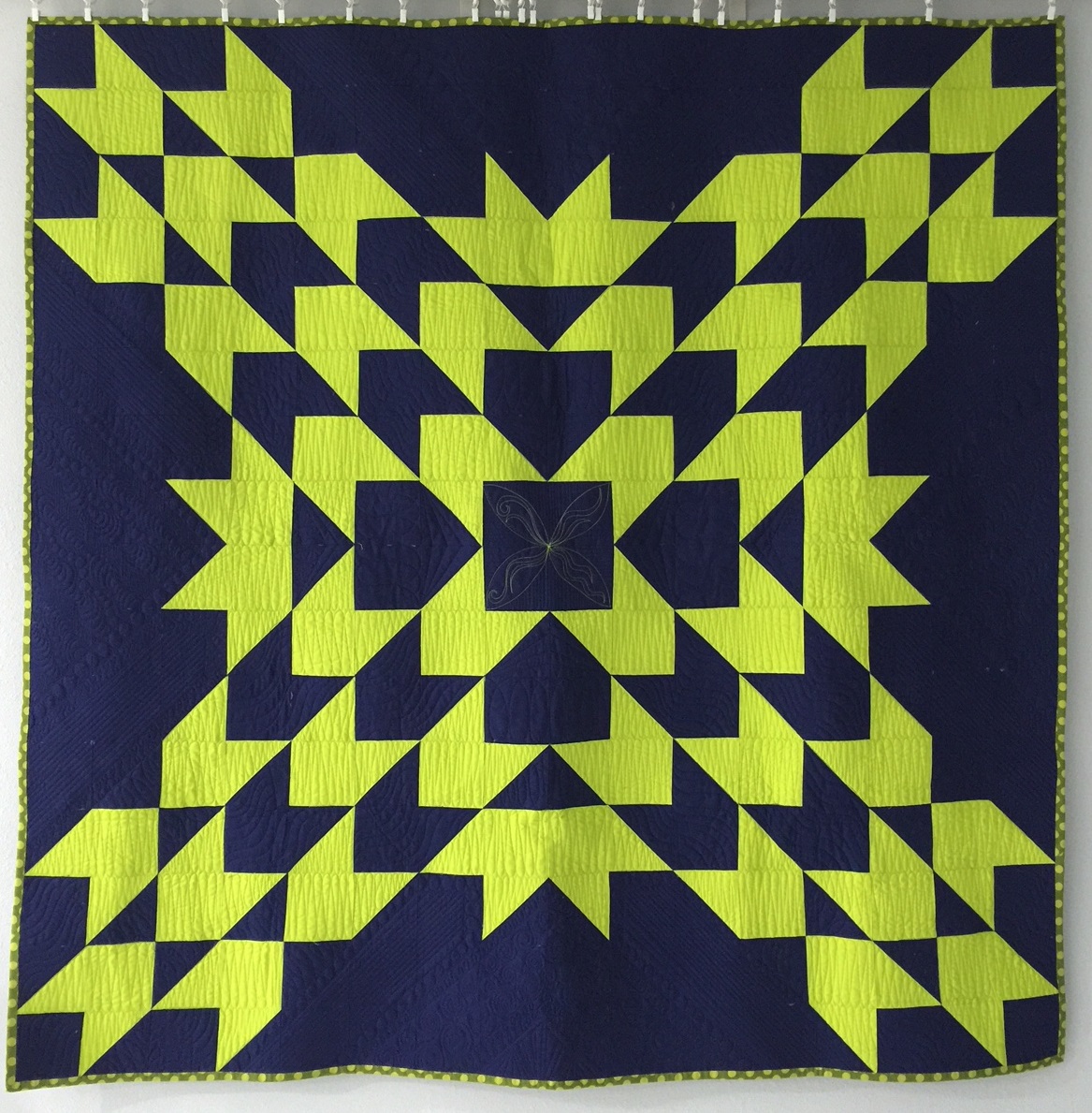A blue and yellow quilt with an arrow pattern.