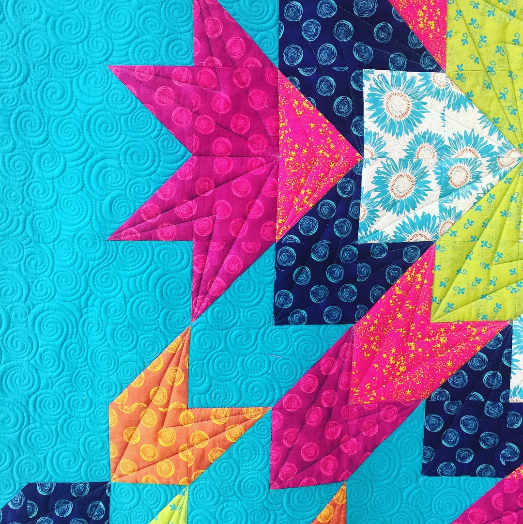 A close up of the quilt with colorful designs