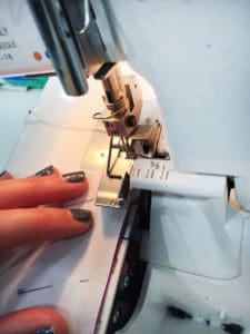 A person using a sewing machine to sew fabric.