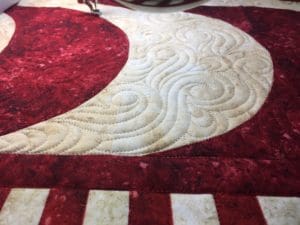 A red and white quilt with a large moon on it.