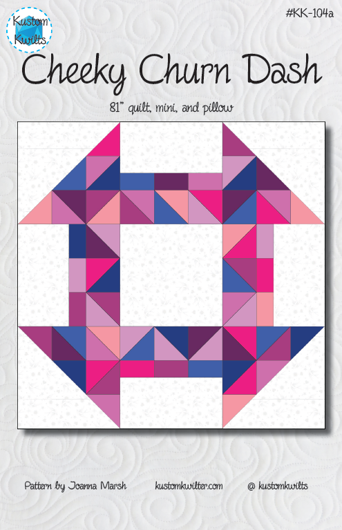 A quilt with a geometric design in pink and blue.