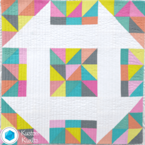 A quilt with colorful squares and triangles on it.