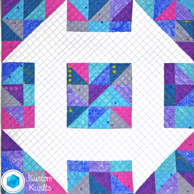 A quilt with squares and triangles in the center.
