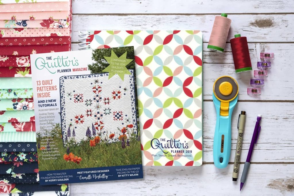 A table with sewing supplies and books on it.
