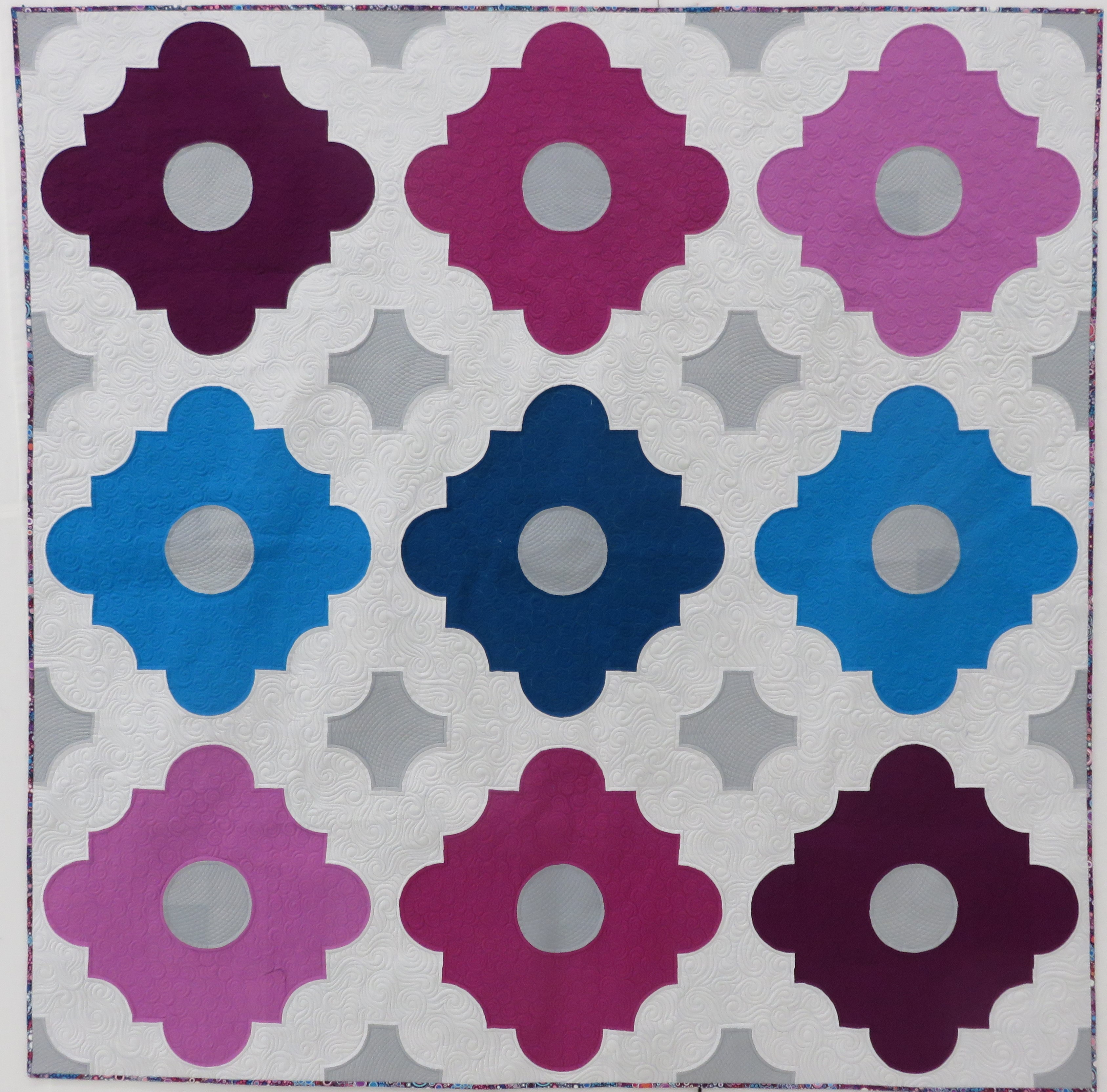 A quilt with different colored squares and circles.