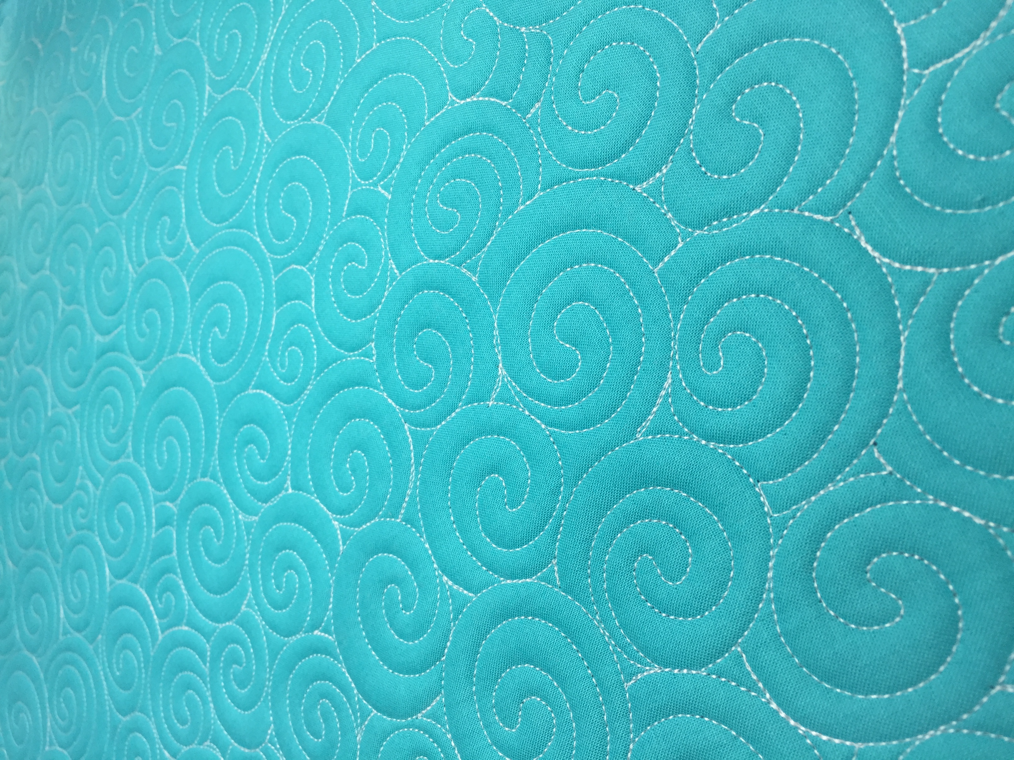 A close up of the swirls on a blue blanket