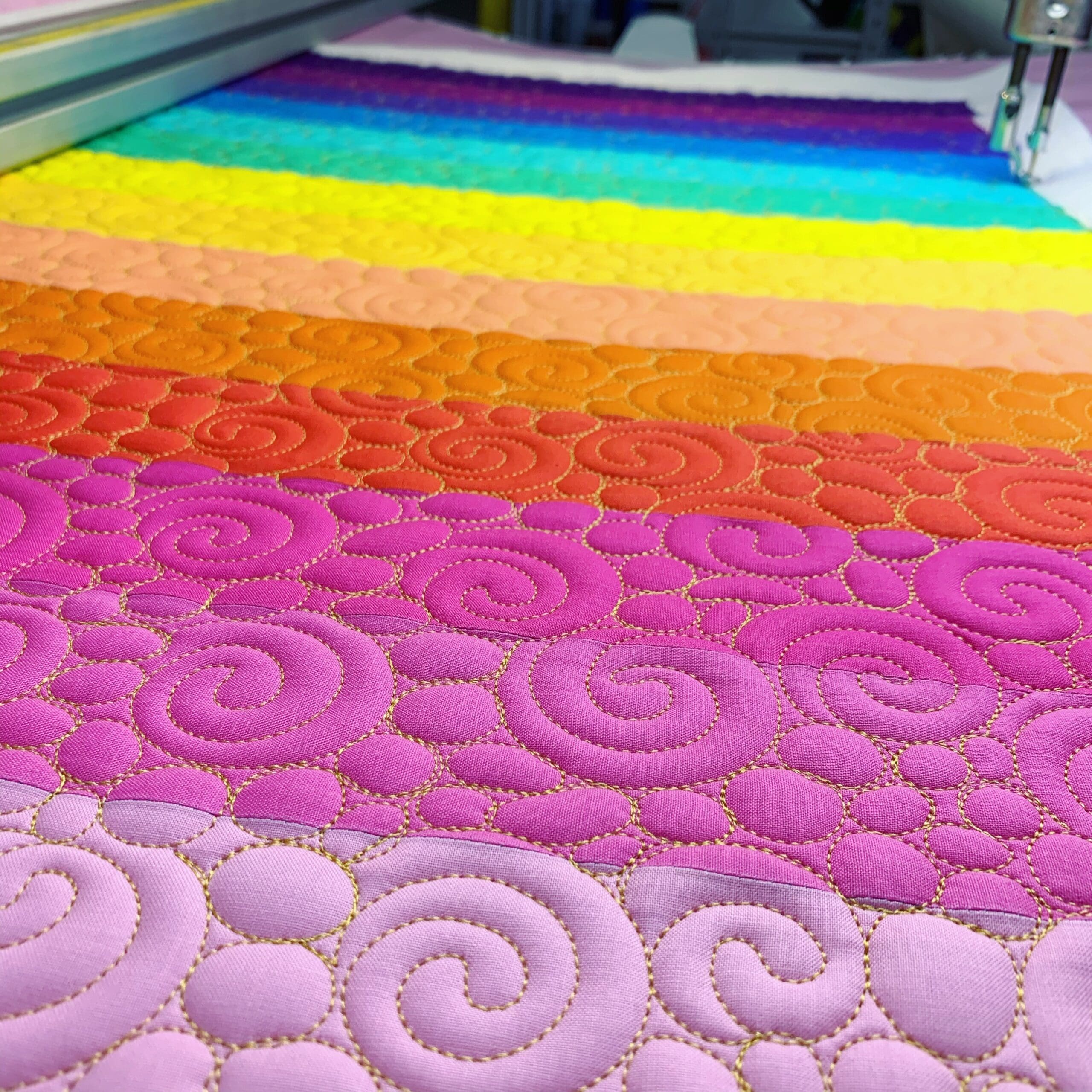 A close up of some colorful quilts being worked on