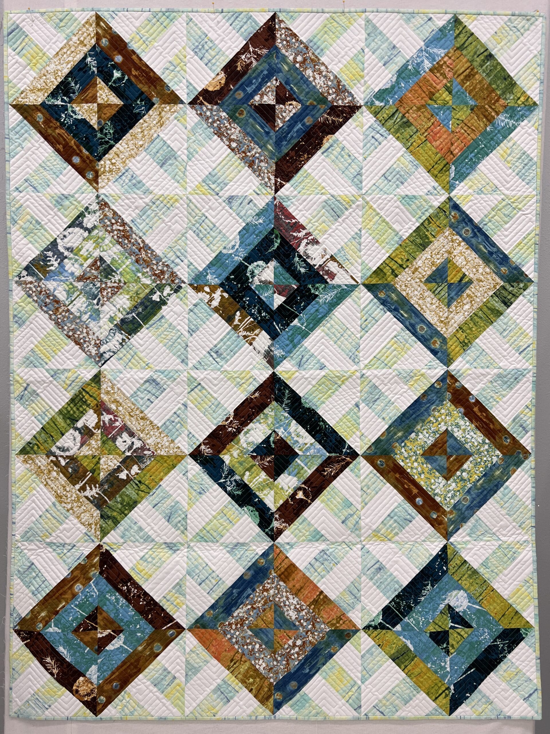 A quilt with squares and triangles in the middle.
