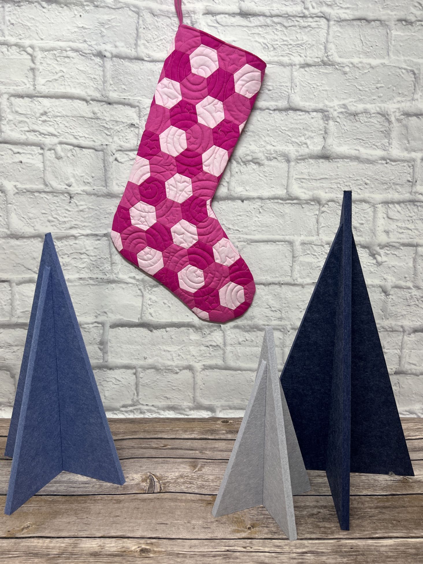 A pink stocking hanging from the side of a wall.