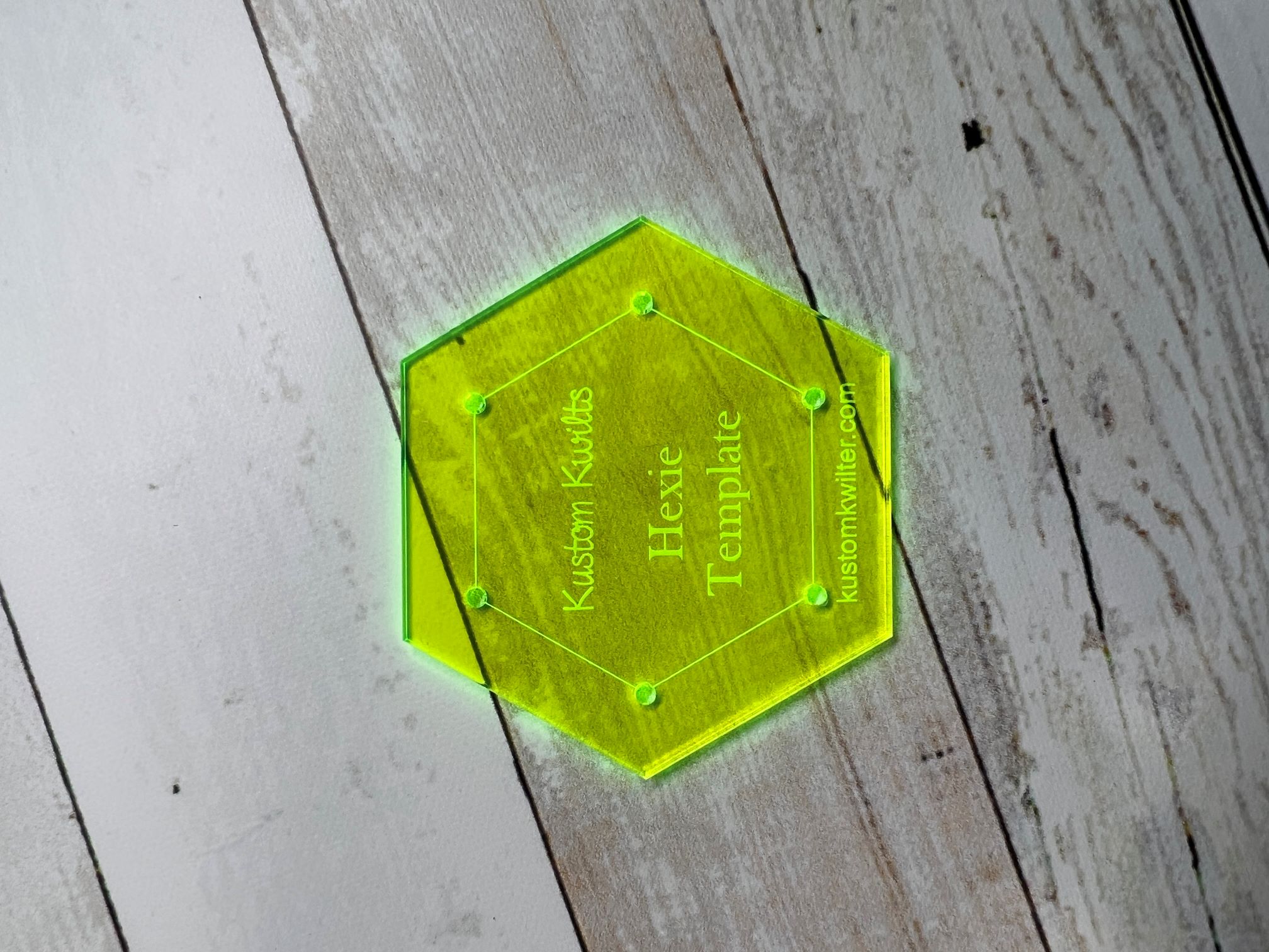 A hexagonal shaped glass coaster with the name of the person.