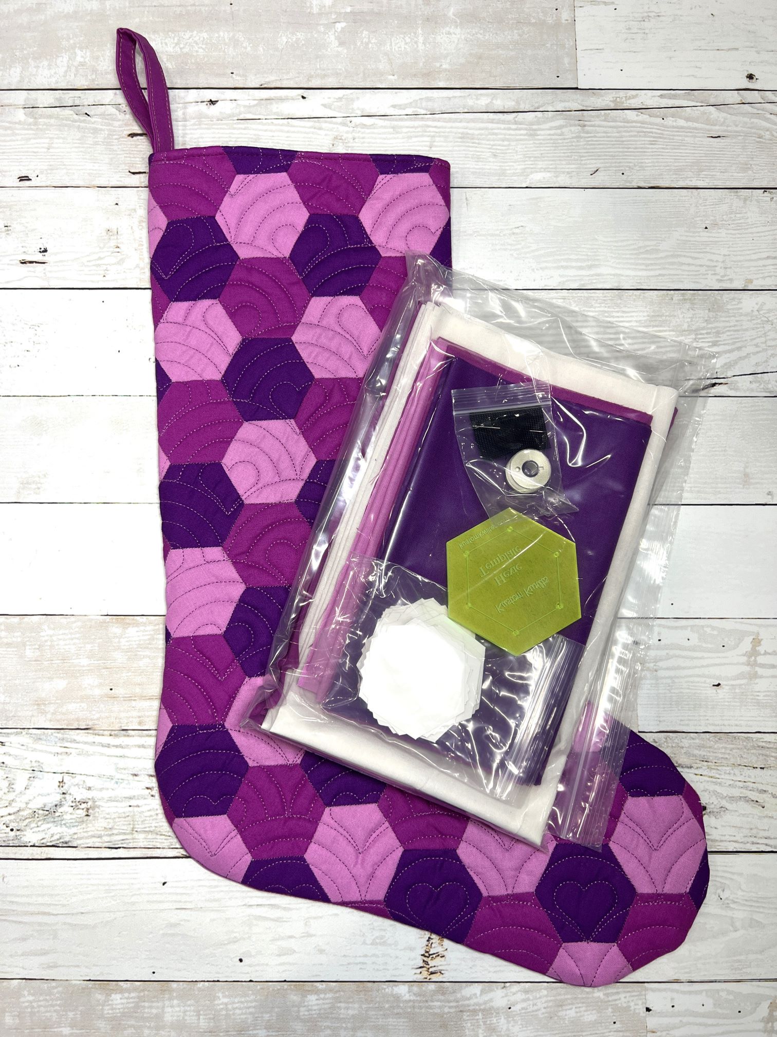 A purple and white stocking with a green owl on it.