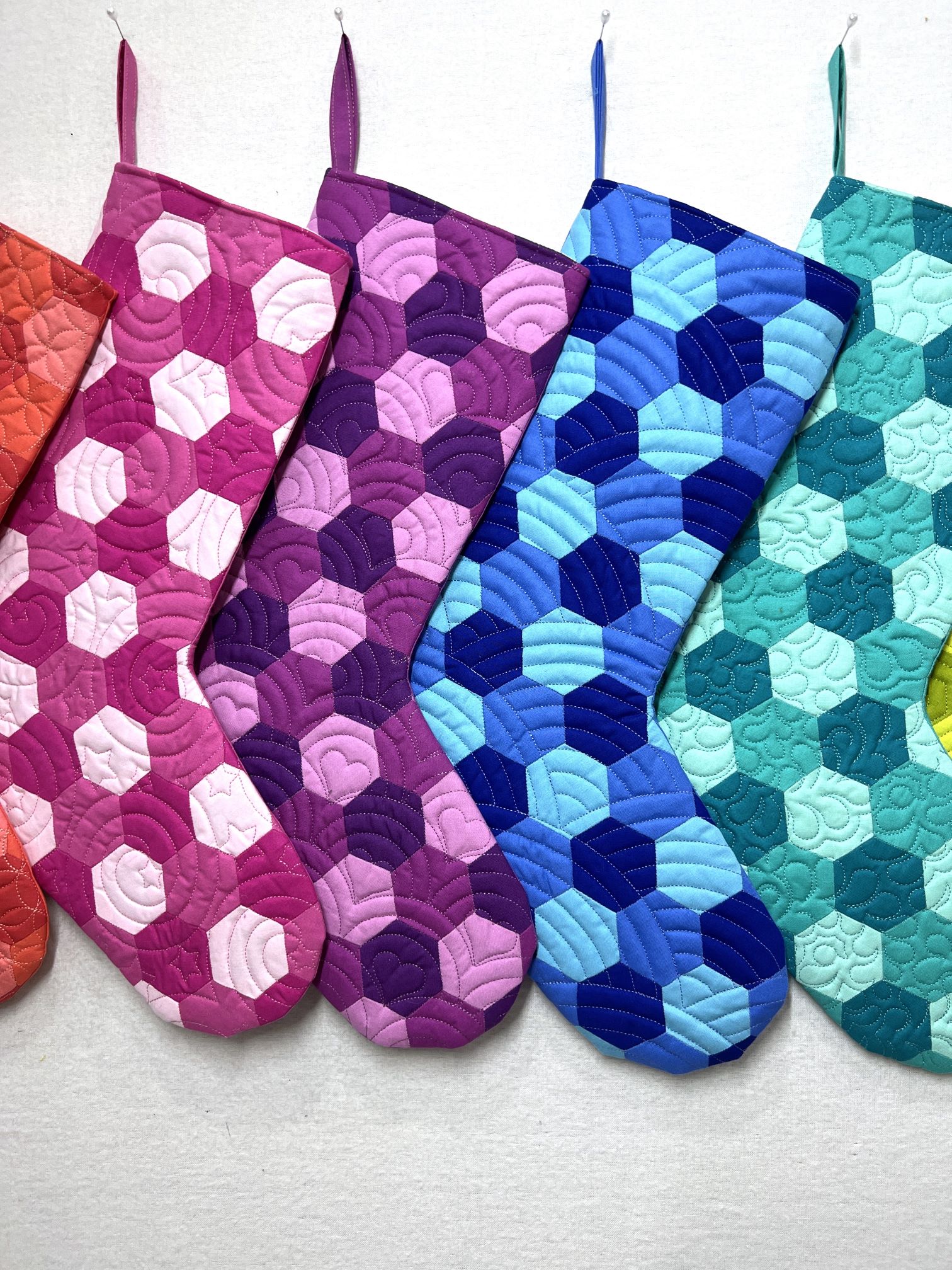 A group of six different colored oven mitts.