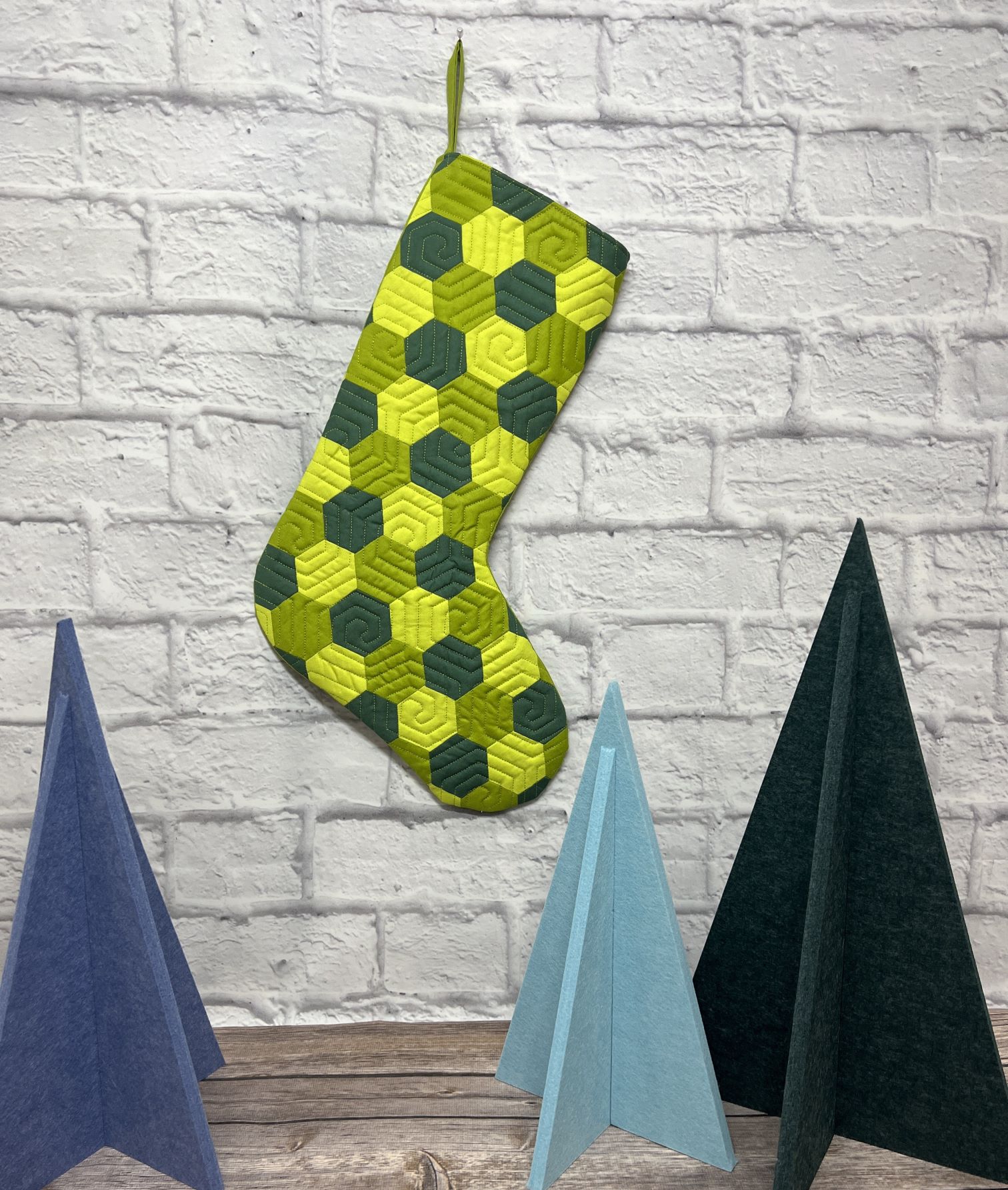 A green and black stocking hanging on the wall
