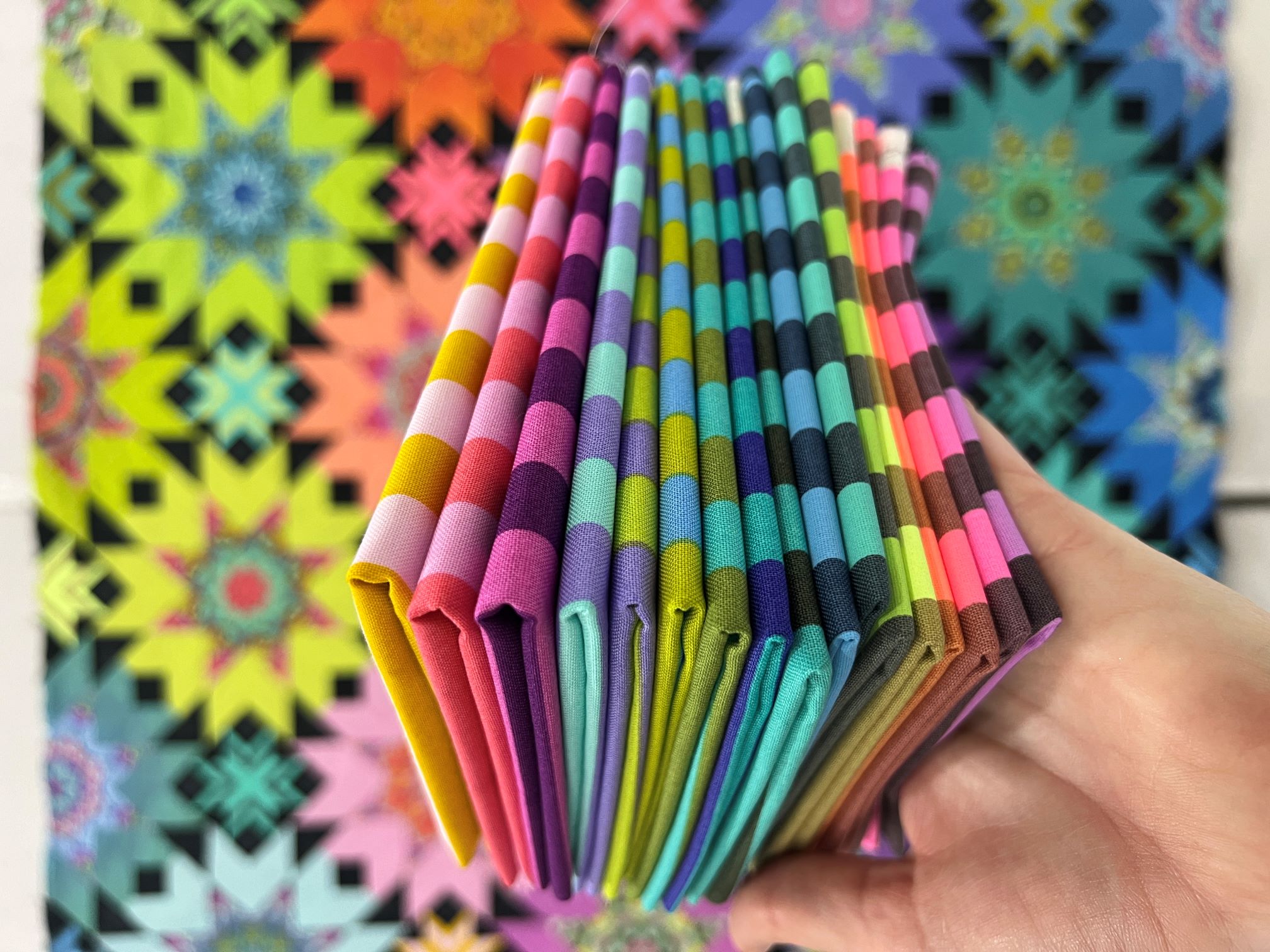 A stack of folded paper in front of a colorful background.